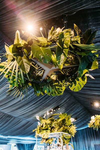 A central, circular bar in the main tent featured a black tambour wood bar with a concrete top. As a focal point, four suspended 4-foot Mercedes-Benz stars adorned with textured greenery floated above.