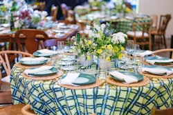 Something Vintage's handmade stoneware plates in a deep green hue sat atop seagrass chargers and alongside shiny gold flatware. Graphic plaid tablecloths from La Tavola Fine Linen dressed up the table. Perfect Settings provided additional rentals for the event.