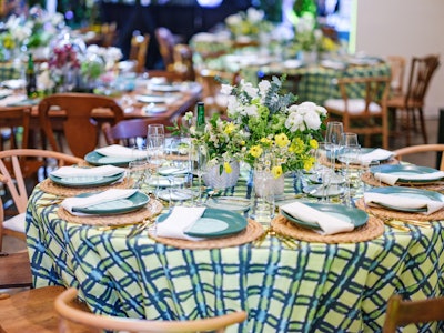 Something Vintage's handmade stoneware plates in a deep green hue sat atop seagrass chargers and alongside shiny gold flatware. Graphic plaid tablecloths from La Tavola Fine Linen dressed up the table. Perfect Settings provided additional rentals for the event.