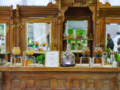 Cocktail Curations served drinks out of globe dispensers. After infusing and crafting the cocktails with botanicals like fruits and herbs in the dispenser, the globe then strained the cocktail directly into each guest's glass. The globes sat perched on Something Vintage's bar made out of 1880s, Victorian-era architectural salvage elements.