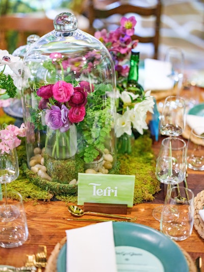 Duran Floral Design's tablescapes went for a wild feel, perched on top of a carpet of moss. Not only were dusty pink and purple blooms showcased under glass cloches, but greenery like clover was highlighted under glass as well.