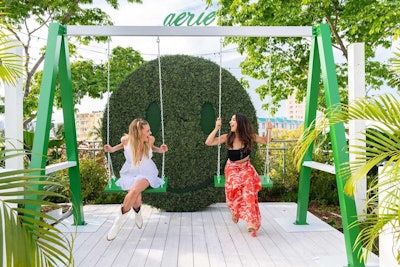 A giant smiley face covered in foliage served as a backdrop for the swing set.