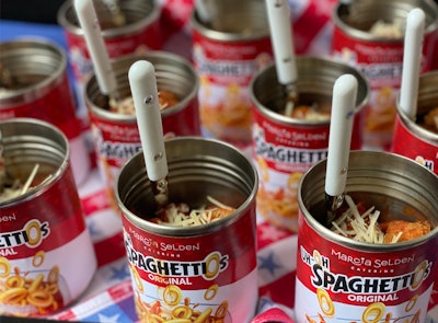 In a tongue-and-cheek nod to SpaghettiOs, a classic American brand, Marcia Selden Catering elevated the meal, which consists of canned, “O”-shaped pasta pieces in tomato sauce. Guests could grab an open-topped can filled with a cheesy pasta dish from a table boasting a red-white-and-blue tablecloth. A fun touch? Jubilee flatware. Oh, and a label that read “Uh-Oh SpaghettiOs” with Marcia Selden Catering’s logo in place of Campbell’s.