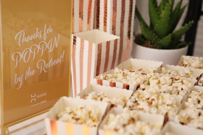 Cleverly placed design elements and signage made guests feel welcome and encouraged social sharing. For example, this table of to-go popcorn thanked guests for 'poppin' by' the Hubilo Retreat.