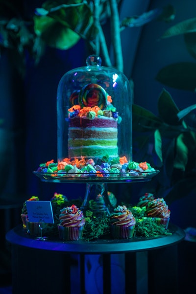 Day glow dessert station with assorted verrines, cupcakes, and colorful candy that glow underneath black light, from Relish Catering & Hospitality in New York