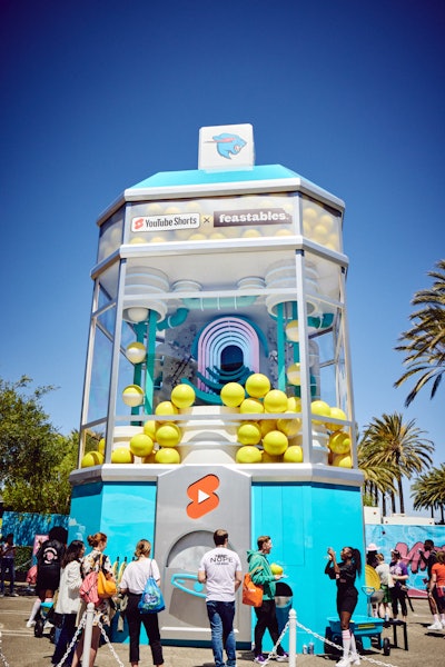 The second activation was a 40-foot-tall gumball machine to promote popular YouTuber MrBeast and his Feastables products of snacks. Fans were able to insert a larger-than-life gold coin, crank the machine up, and watch as a huge, bright yellow gumball rolled down the shoot. Once in hand, guests cracked open their gumballs to receive prizes. And in a surprise-and-delight moment, as part of his Wheel of Wins Campaign, MrBeast himself also made a guest appearance and presented one winner with a Tesla.