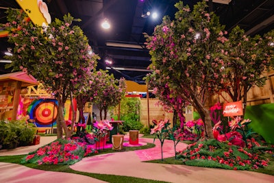 After stepping past vintage-style posters and through a wooden camp overhang, attendees entered Starburst’s pretty-in-pink “feel-good forest.” Guests were invited to write encouraging, positivity-focused messages for each other, which were then hung from the trees with wooden clips. A vibrant pink carpet featured hashtags like #doyou, and neon signage said “you are a pink Starburst.”