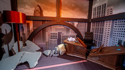 The final room brought guests into an animated world, depicting the corner office of Titan from Invincible. The office was visibly destroyed from the aftermath of a fight with Machine Head, including holes in the walls, pieces of concrete on the floor, a custom-fabricated broken desk, and more. Guests were given the opportunity to become a superhero through a Dupli-Kate superhero photo op. Then, as the big finale of the experience, attendees climbed up a stairwell in the office building to the second-floor roof, opened the roof door overlooking all of VidCon, and were able to take a leap into the foam pit below.