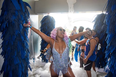 To enter, guests walked through a 16-foot-wide misting arch to cool off before encountering a dance floor complete with foam cannons, spinning brushes, and drying fans. Brand ambassadors invited festivalgoers to pose with props. The activation was produced in partnership with MC2 and Bearded Kitten.