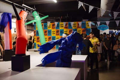 Upon entering the event, guests were greeted by staffers dressed as car wash attendees. Decorative Jerry cans were lined up throughout the space, which was embellished with slogans such as “Get Hosed at the MKG Summer Party” and “When in Foam.” The dance floor was constructed on elevated platforms designed to look like a car-wash conveyor belt, and decorations included car-wash air dancers.