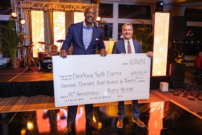 John Tallichet (right) presented a $19,720 donation check to Alonzo Mourning’s Overtown Youth Center, which assists at-risk Miami youth and their families.
