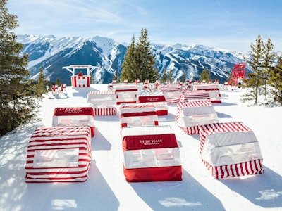 Seaside met slopeside at 'Snow Beach,' where artist Gray Malin brought one of his signature aerial beach photographs to life—in the snow—to celebrate the luxury of après-ski culture. Malin, known for his visionary aerial photography, partnered with retail and experiential brand ASPENX to outfit a corner of Aspen, Colo.'s Ajax Mountain in early 2022 in red-and-white striped cabanas, chaise lounges, umbrellas, and chairs. 'The red was a nice pop of color to the landscape, while the striped white offered a clean and simple look. This color combo also worked well with the beachy elements we incorporated, from constructing the lifeguard tower to the surfboards to the lounge seating and cabanas,' Malin said of where he drew inspiration for the installation. See more: Gray Malin’s Mountainside Snow Beach Club Is Bringing Miami Heat to Après-Ski