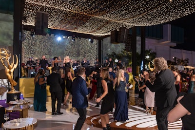 The gala band Collective LA—comprising singers Amber Nicole, Dani Moz, Brennan Villines, Bryon Dodson, and Bel-Ami—kept guests on their feet under the light canopies. The band was presented by Downbeat Agency. And even though LA weather wasn't as cooperative as it could've been on the days leading up to the outdoor event—temperatures were higher than normal and strong winds from a nearby tropical storm were in effect—Cecchetto said her dedicated team was vital in mounting those challenges. 'Every one of us will roll up our sleeves and make it work,' she said. 'There's absolutely nothing we don't do. ... And the trust of the Television Academy, with Barb Held and Maury McIntyre, has been absolutely priceless.'