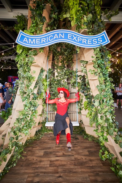 The physical space was anchored by an extravagant two-story tree structure made out of cardboard and fake green plants. The truck of the tree on the ground level opened into a photo op with a swing. One side of the top of the tree served as the backdrop of the bar area, and the other side is part of the alfresco patio decor.