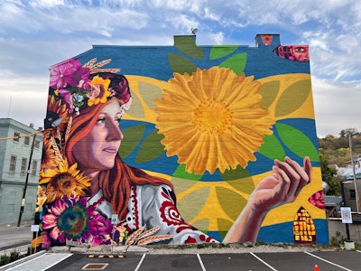 Muralist Jenny Ustick and motion designer Sean Hafer—both University of Cincinnati art professors—created a piece titled Sister City. It depicts a Ukrainian woman wearing traditional clothing, including a flower headdress. The mural was a collaboration between the Cincinnati-Kharkiv Sister City partnership and cincy4ukraine.