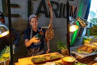 The “carnivore” station featured maple-glazed salmon, jerk-rubbed pork loin, a hanging tomahawk steak, whipped truffle potato, and grilled Caesar salad.