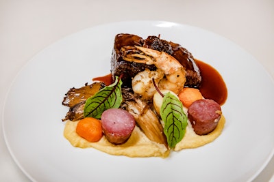 The dinner entree included braised short rib, fennel-dusted shrimp, parsnip puree, oyster and morel mushrooms with Thumbelina carrots, crispy fingerling potatoes, crispy spring roll shell, fried parsley, and oregano.