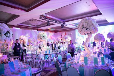 The aquatic-themed Grand Ballroom hosted elegant white tablescapes with white floral centerpieces and teal accents.