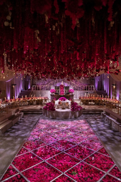 For a Dallas wedding at a private home in 2021, Birch Event Design created cascading floral installations using blooms ranging from pale pink to deep magenta. The plexiglass-covered pool was filled with rose petals of the same hue.
