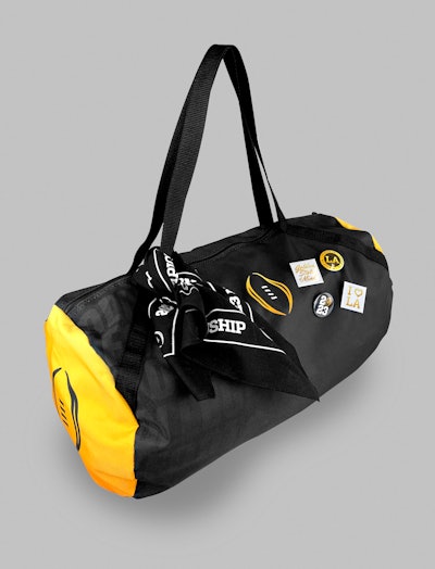 One of the duffel bags up close, complete with a branded bandana and decorative pins.