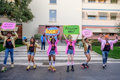 Roller skaters holding classic comic book-inspired signs welcomed guests to the event; inside, they performed choreographed routines and kept the party lively, referencing the roller skating featured prominently in the series.