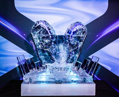 A goat head ice sculpture, illuminated by AXE-themed colored lighting, was created by Okamoto Studios.