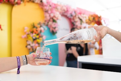 An abundance of roses decorated the colorful and extensive Cote des Roses wine bar inside the Grand Tasting tents, where empty bottles doubled as vases. In addition to a photo booth, there was a Post-It note station encouraging guests to leave messages and “send a rose” using a shoppable QR code.