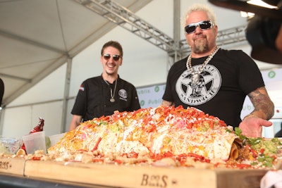 Inside the Publix Culinary Demonstrations tent, Guy Fieri worked a hungry crowd while constructing a fully loaded and larger-than-life El Queso-Taquito-Burrito. He paired it with batched Santo kiwi-strawberry margaritas—with help from fellow chefs and his son, Hunter.
