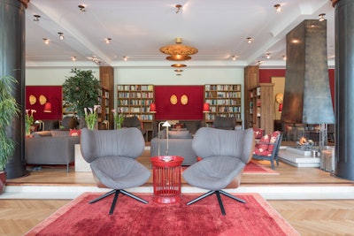 The Library Lounge at Schloss Elmau's Retreat features two open fireplaces and spectacular views of Wetterstein Mountain and Ferchenbach Creek.