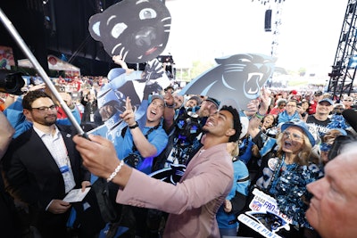 Alabama quarterback Bryce Young posed with Carolina Panther fans after being selected as the first pick in the draft.