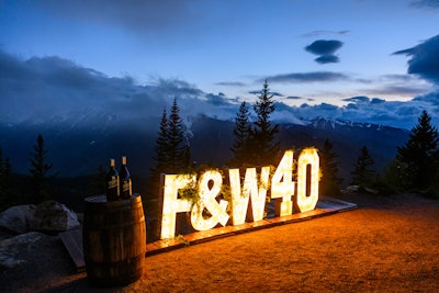 Signature F&W signage with a celebratory “40” illuminated at night atop Aspen Mountain.