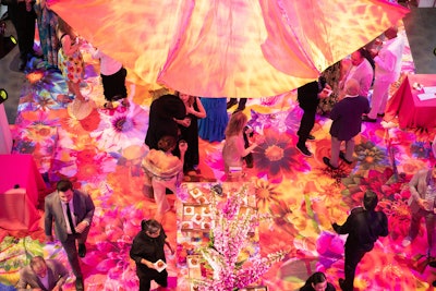 Decor at the dinner reception was a “maximalist, trippy color explosion,” Williquette says. A bright floral vinyl wrap covered the museum’s floor, requiring overnight installation.