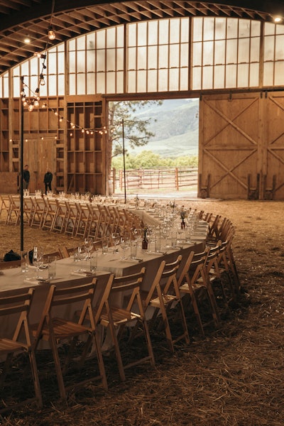 Due to weather conditions, the family-style dinner was relocated inside the McCabe Ranch barn. String lights complemented by an old tractor and the natural design of the space lent to the massive circular arrangement of the farm-to-table, family-style dinner, which featured local ingredients from more than a dozen Colorado suppliers. Kitchen Garden Textiles provided linens, Heath Ceramics supplied plating, and florals were from Juniper Flowers.