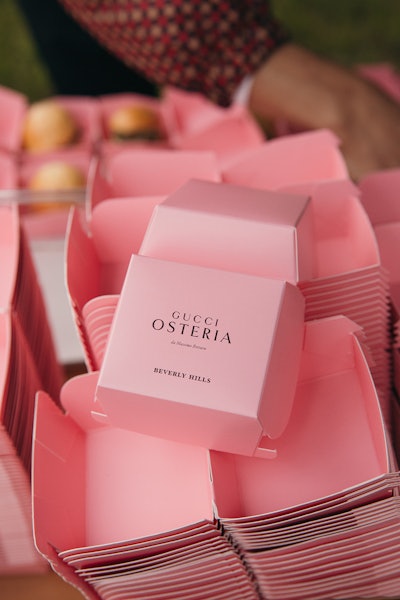 During the outdoor cocktail hour, guests enjoyed local lamb sliders served inside mini, eye-catching, pink-branded boxes.