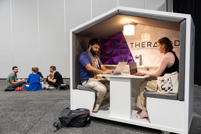 Near the expo, the business lounge offered a comfortable refuge with refreshments and snacks, various seating areas, and Therapod stations for those in need of pop-up work areas.