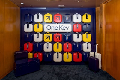 The step-and-repeat featured custom-fabricated suitcases showcasing the icons and colors of Expedia Group’s three flagship brands—Expedia, Hotels.com, and Vrbo—all centered on the One Key logo.