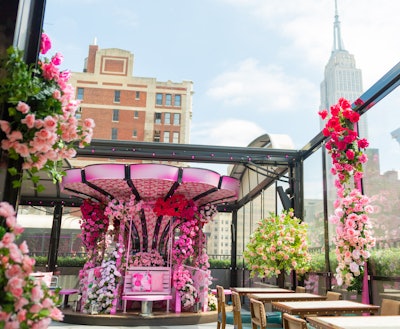 In summer 2021, Moxy Times Square’s Magic Hour Rooftop Bar & Lounge debuted a rooftop rose garden complete with over 10,000 roses, along with photo ops; pink rose cocktails; and other fun, themed treats like the “Pink AF Pancake Stack.” Highlights include a carousel wrapped in a custom rose print, walls covered in roses and greenery, and florals draped in an ombré pink palette.