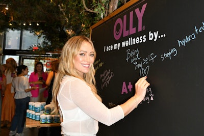 Experiential agency Coffee ’n Clothes designed the space with an elevated back-to-school theme, including a chalkboard installation where guests wrote down how they ace their own wellness. There were also quizzes to determine which OLLY products were right for each guest, and various nostalgia decor elements to remind guests of their own school days.