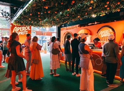 In a fun ode to an orange tree, guests who looked up as they awaited their turn to order an Aperol Spritz surely marveled at the orange tennis balls that hung from a leafy ceiling. Elsewhere on the stadium grounds, Aperol served its beloved summer cocktail out of an authentic Italian Apé truck. For those who couldn’t make it courtside, Aperol also teamed up with mixed drink delivery service Cocktail Courier to offer the Perfect Serve Kit, which comes with Cinzano prosecco, Aperol, club soda, and an orange–the ingredients for an Aperol Spritz. The kit, which makes up to 12 cocktails and sells for $82.99, also comes with a branded visor and recipe card.