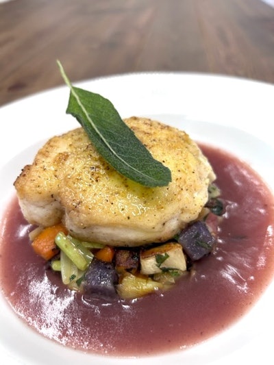 Atlanta-based event catering company Proof of the Pudding is serving lemon-crusted halibut on roasted root vegetables in a red wine beurre blanc.