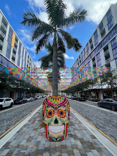 The Fountain Plaza features an altar display of a trio of catrines (male skeleton figures) with flowers, marigolds, papel picado, and more.