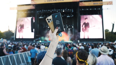 A fan powering up with chargeFUZE at the ACL main stage.