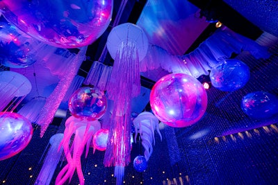 To create the lounges, the team rigged 24-by-24-foot trusses to the ceiling, then added over 60 20-foot crystal curtains. Inside the structure, airline cable was used to hang over 32 jellyfish of various sizes, along with iridescent balls in three sizes to create a bubble effect. “Various strips of crystal curtains were weaved into the design,” added Taylor. “The finishing touch was the custom curved wave hardware with white chiffon fabric to emulate crashing waves.”