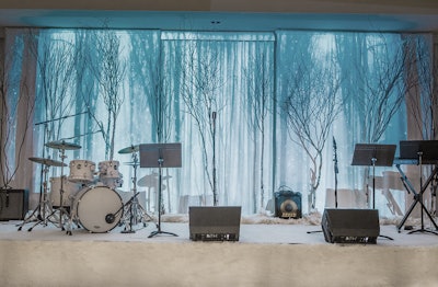 Attendees were treated to an ice bar and vodka luge while an eight-piece band played in front of a birch forest backdrop on a fur-upholstered stage. An interactive photo booth offered thematic props including bear paws, antlers, ice crowns, and earmuffs.
