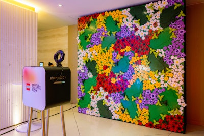 A Sharingbox photo booth with a floral LEGO backdrop invited guests to pose and share their visits.