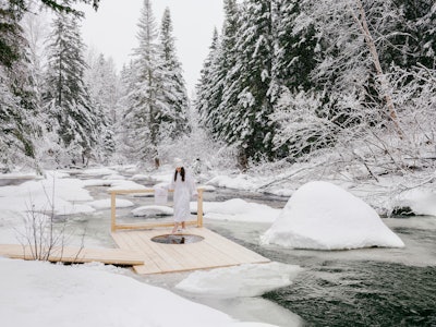 The experience also features luxury spa amenities like massages, a cold plunge station built into a national riverbank, a sauna and outdoor hot tub, and a selection of Quebecois charcuterie and snacks.