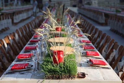 To build buzz for a product collaboration with Feed Projects in 2013, Target invited Manhattan’s fashion-forward set to cross the river for a rustic-Americana-themed dinner party underneath the Brooklyn Bridge. On the wooden farm tables, Hatch Creative Studio punctuated wheatgrass flats with wheat stocks and red Mason jars holding candles. Custom red bandannas printed with event details served as napkins, and family-style bowls of pickled beet, wheat berry, and kale salads sat atop platforms made from tree trunks. See more: 18 All-American Decor Ideas From Feed U.S.A. for Target Launch