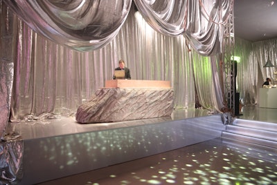 The main space featured vintage theatrical drapes evoking nostalgia, juxtaposed with modern furnishings and a repurposed studio prop transformed into a DJ booth. UMG enrolled the artists of O.M. Studio to further enhance the ambiance with hand-welded candelabras and organic sculptures.