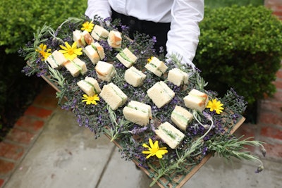 Bites & Bashes passed bites on trays decorated with organic details including flowers and sprigs.