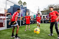 In January 2023, Universal CityWalk in Orlando was home to a Premier League Mornings Live fan fest for two days, celebrating fans of world-class soccer. Throughout the event, more than 9,600 fans of all ages enjoyed eight massive LED screens for live match viewing, plus on-site consumer activations, talent meet-and-greets, player visits, free merchandise, and more. The Premier League fan fest events are purposely kept family-friendly, the organizers told BizBash—noting that several experiential offerings were particularly popular with younger fans, like photo ops with the Premier League club mascots and the Premier League trophy, EA Sports-sponsored gaming stations featuring FIFA 23, airbrush tattoos, and a football pitch sponsored by Nike (pictured). See more: How NBC Sports and Premier League Hosted a Huge Fan Event Inside a Theme Park